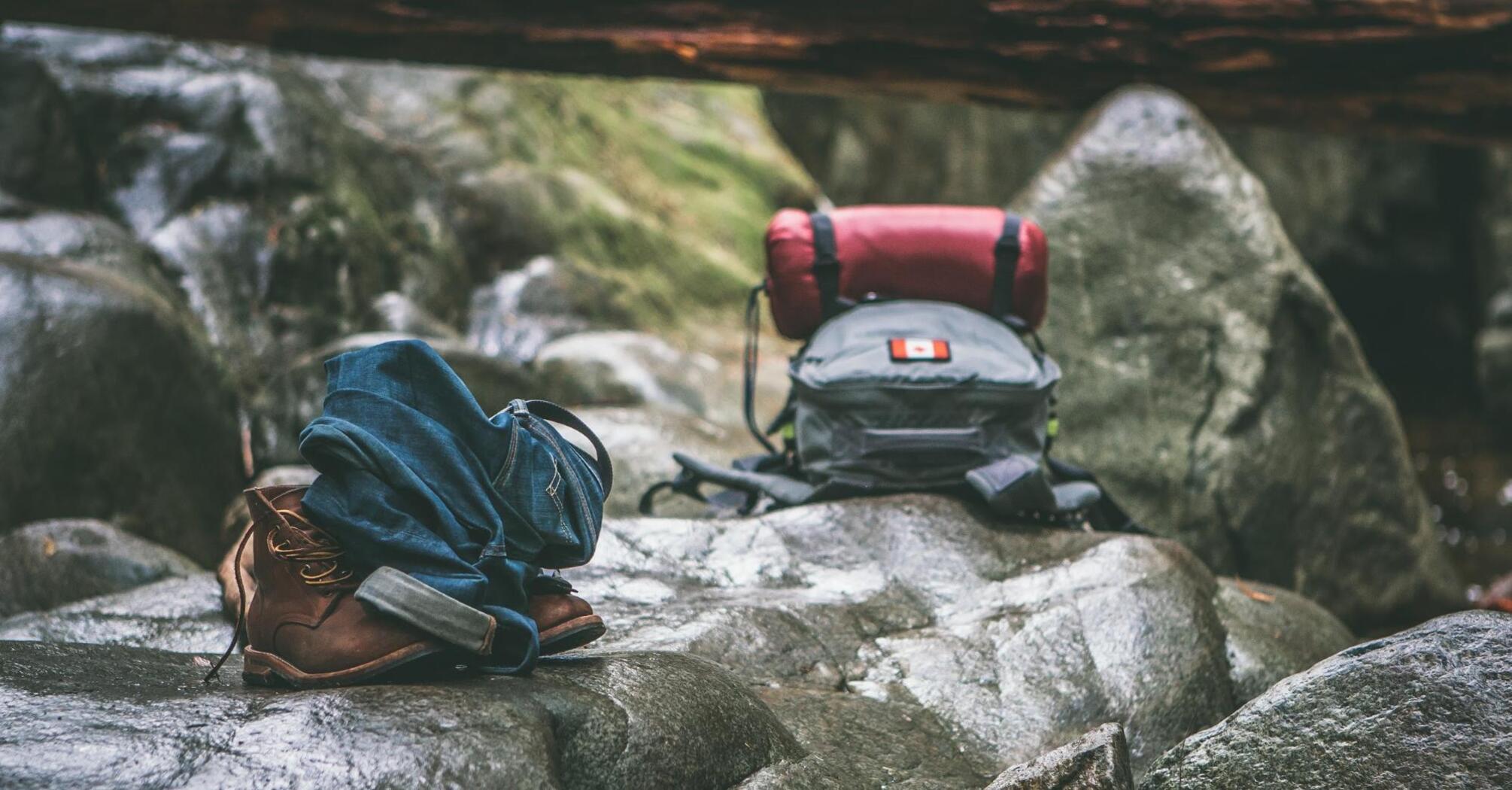 Ready for hiking: backpack and boots on rocks