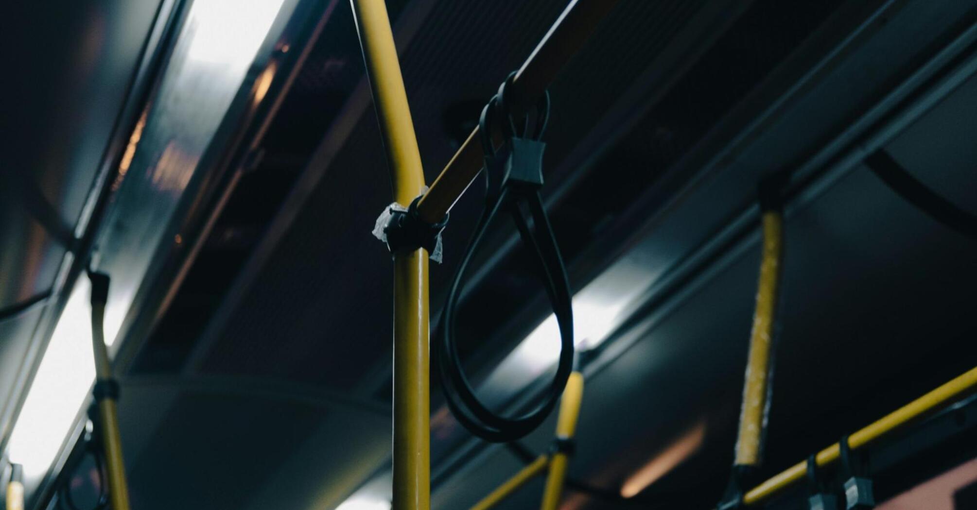 Interior of a bus with yellow handrails and loops