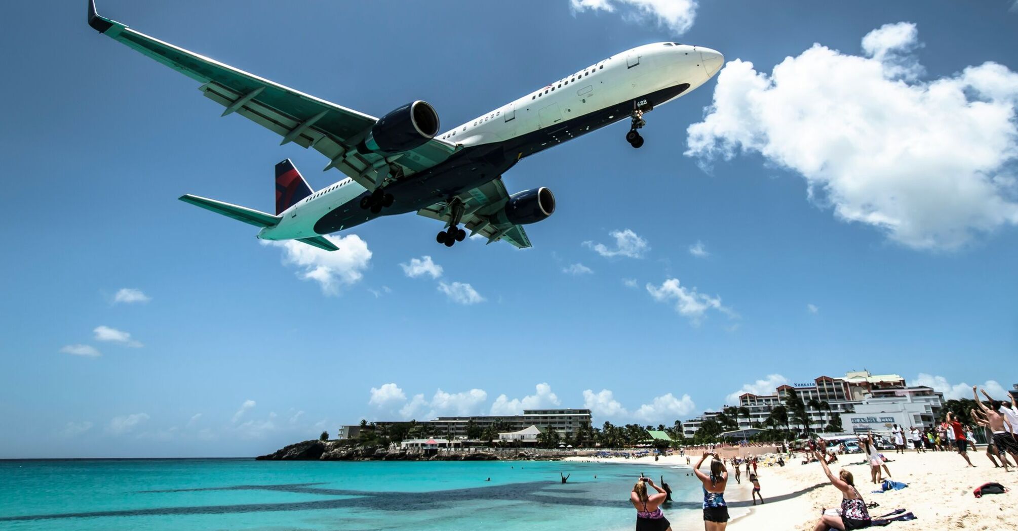 delta airlines plane landing near seashore during daytime