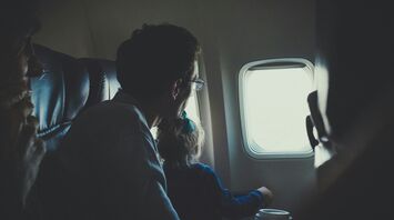 Father and child looking out airplane window