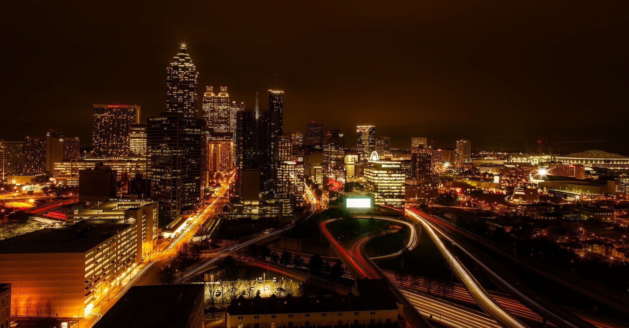 Night view of Atlanta city skyline with illuminated buildings and busy highways