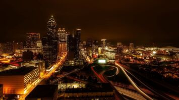 Night view of Atlanta city skyline with illuminated buildings and busy highways