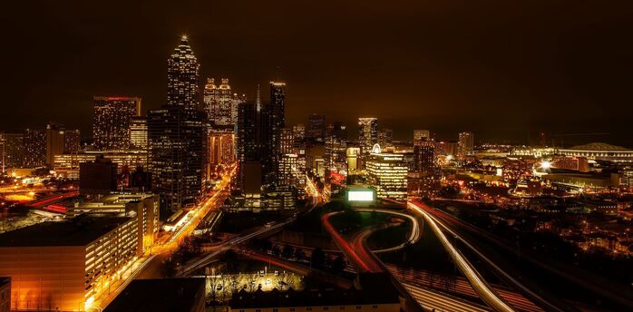 Night view of Atlanta city skyline with illuminated buildings and busy highways