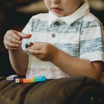 Young child playing with colorful building blocks