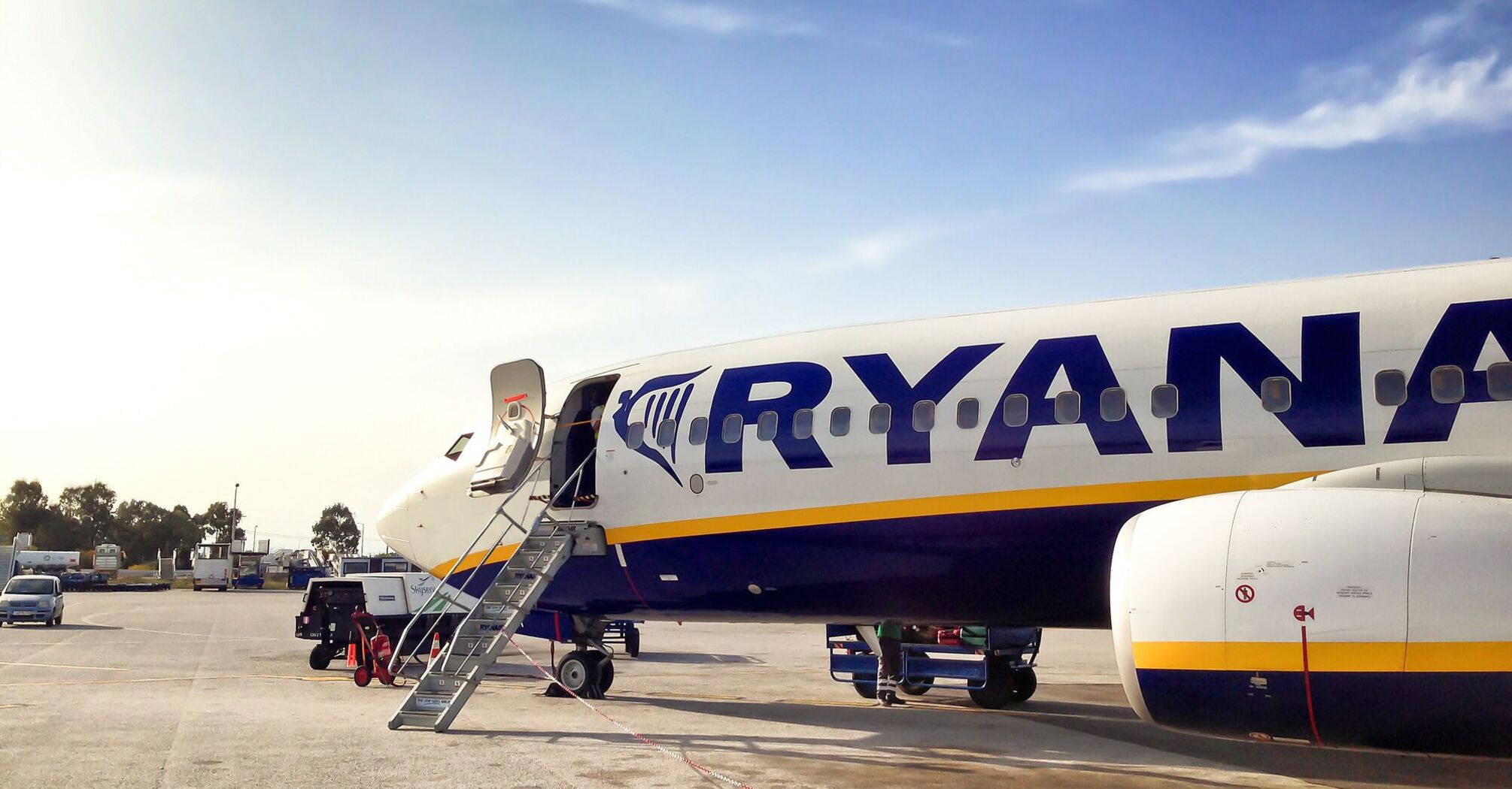 Ryanair aircraft parked at an airport with open boarding stairs