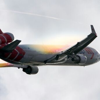 White and red airplane under white clouds during daytime