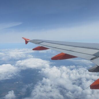 View from an EasyJet airplane window showing the wing and clouds