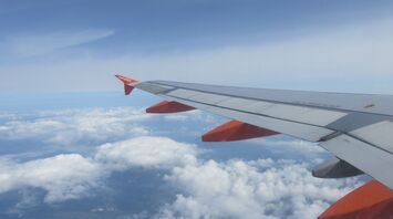View from an EasyJet airplane window showing the wing and clouds