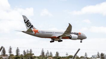 A large jetliner flying through a blue cloudy sky