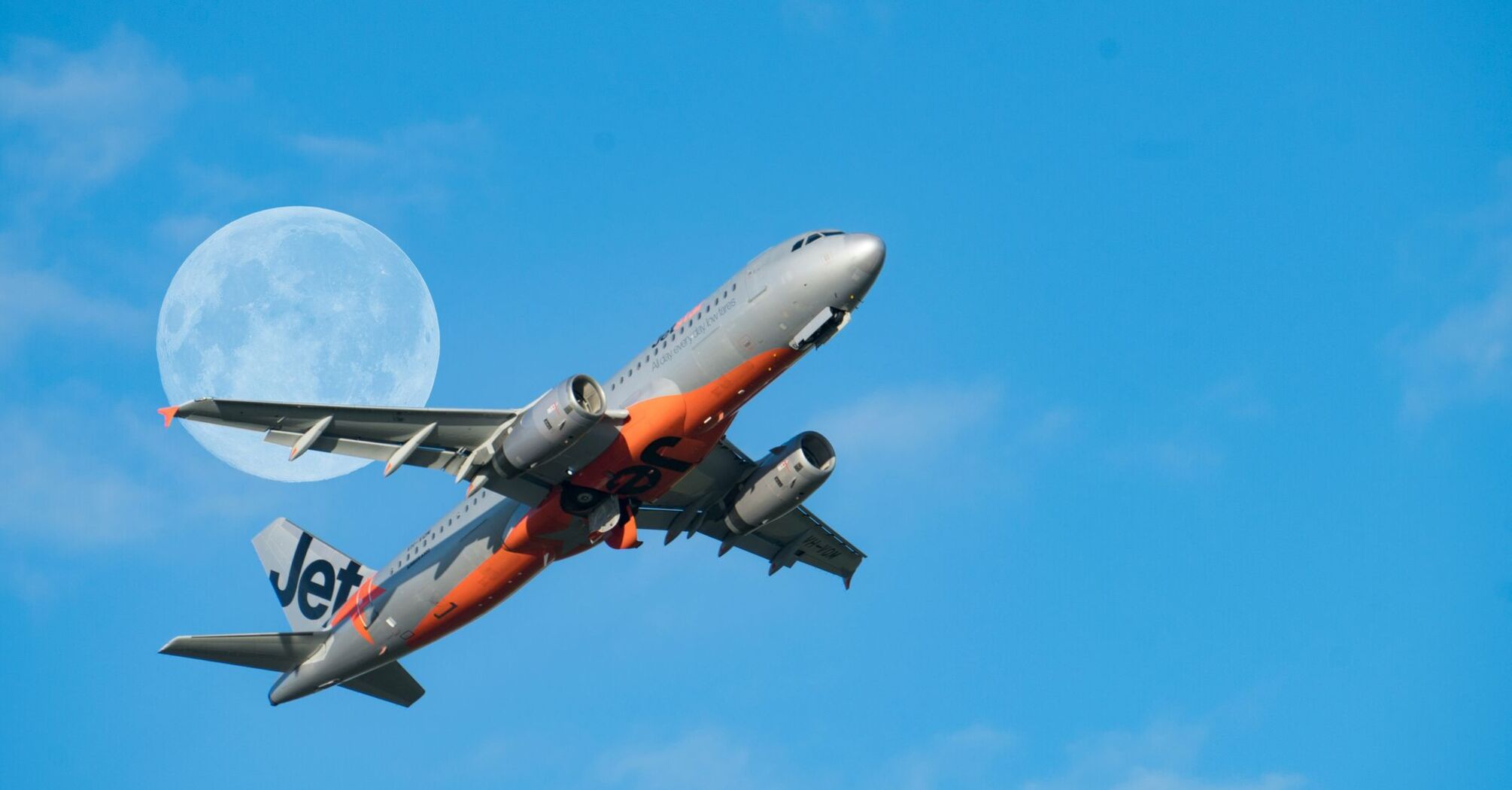 low angle photography of gray and red Jetstar passenger plane