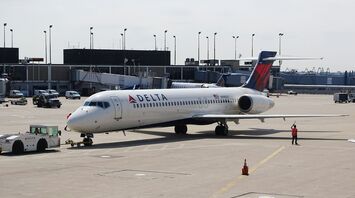 Delta Airlines aircraft at the gate with ground crew