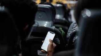A person using a smartphone while traveling on a bus
