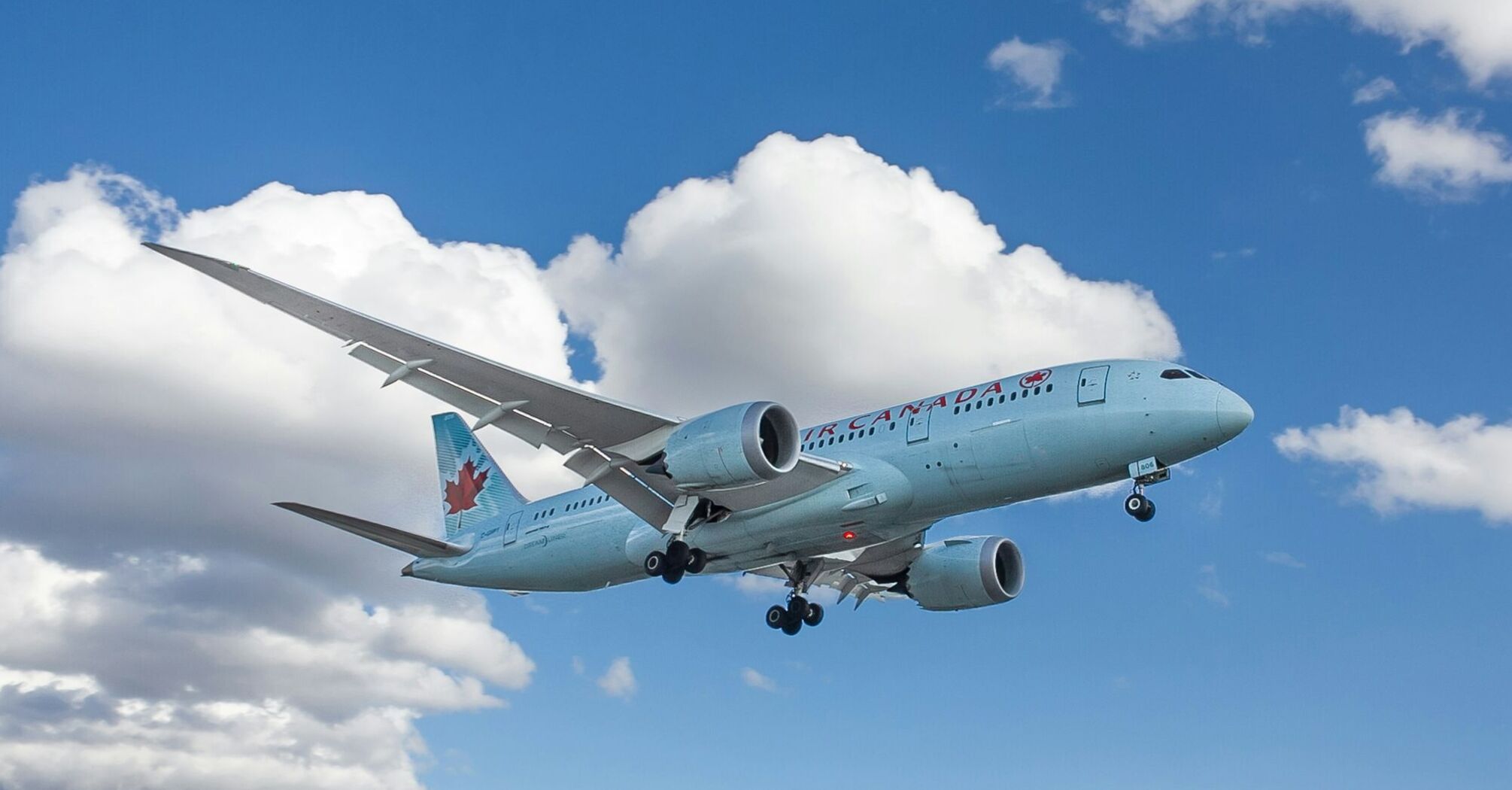 Air Canada airplane in flight with Olympic-themed livery