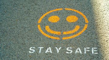 Yellow smiley face and 'Stay Safe' painted on pavement