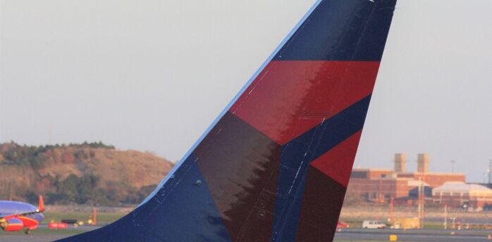 Close-up of a Delta Air Lines aircraft tail showing the red, blue, and dark blue livery
