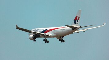A large jetliner flying through a blue sky