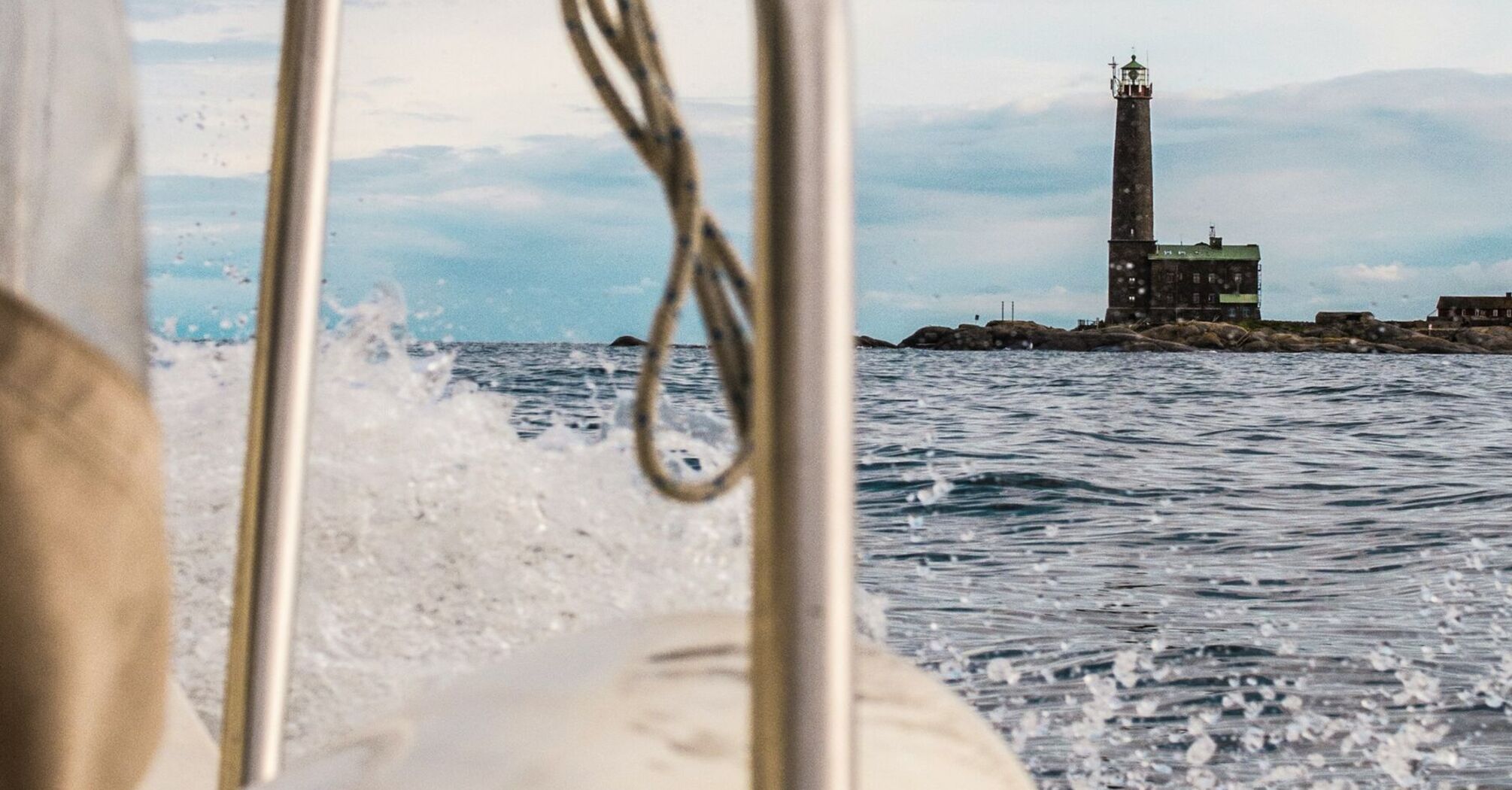 View of a lighthouse on Kimitoön Island from a boat, showcasing the rugged charm of the Finnish archipelago
