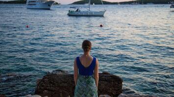 Girl looks at ships passing by