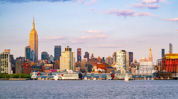 City skyline of New Jersey, viewed from a boardwalk across the water at sunset