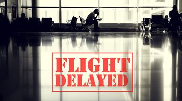 Silhouetted person sitting at airport gate with 'FLIGHT DELAYED' sign overlay