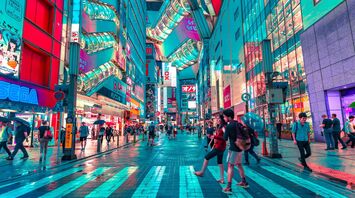 People walking on road near well lit buildings