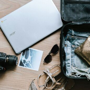 Open suitcase on a wooden floor packed with travel essentials