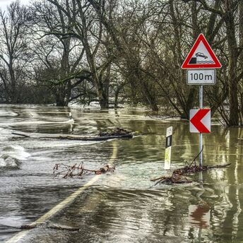 Flooded roadway with warning signs