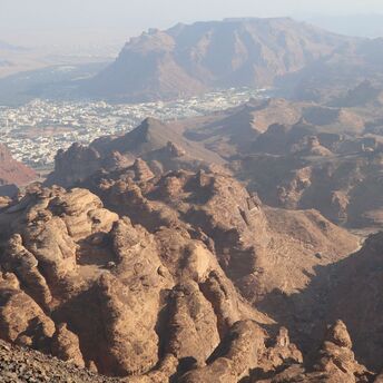 Aerial view of Harrat Viewpoint overlooking the rocky landscape and cityscape of Al-'Ula, Saudi Arabi