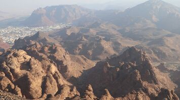 Aerial view of Harrat Viewpoint overlooking the rocky landscape and cityscape of Al-'Ula, Saudi Arabi
