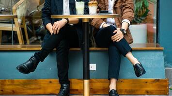 Couple with two coffees sitting at a table