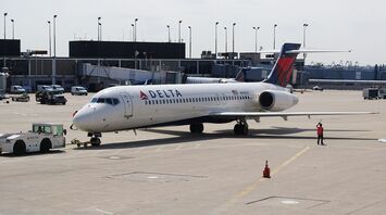 Man standing beside white delta airplane
