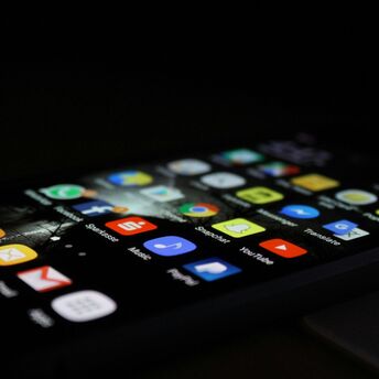 Smartphone displaying various application icons in a dark environment