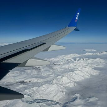 View from a Flydubai airplane wing over snowy mountains
