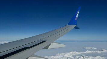View from a Flydubai airplane wing over snowy mountains