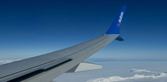 View from a Flydubai airplane wing over snowy mountains