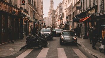 Vehicles travelling on road surrounded by buildings during daytime