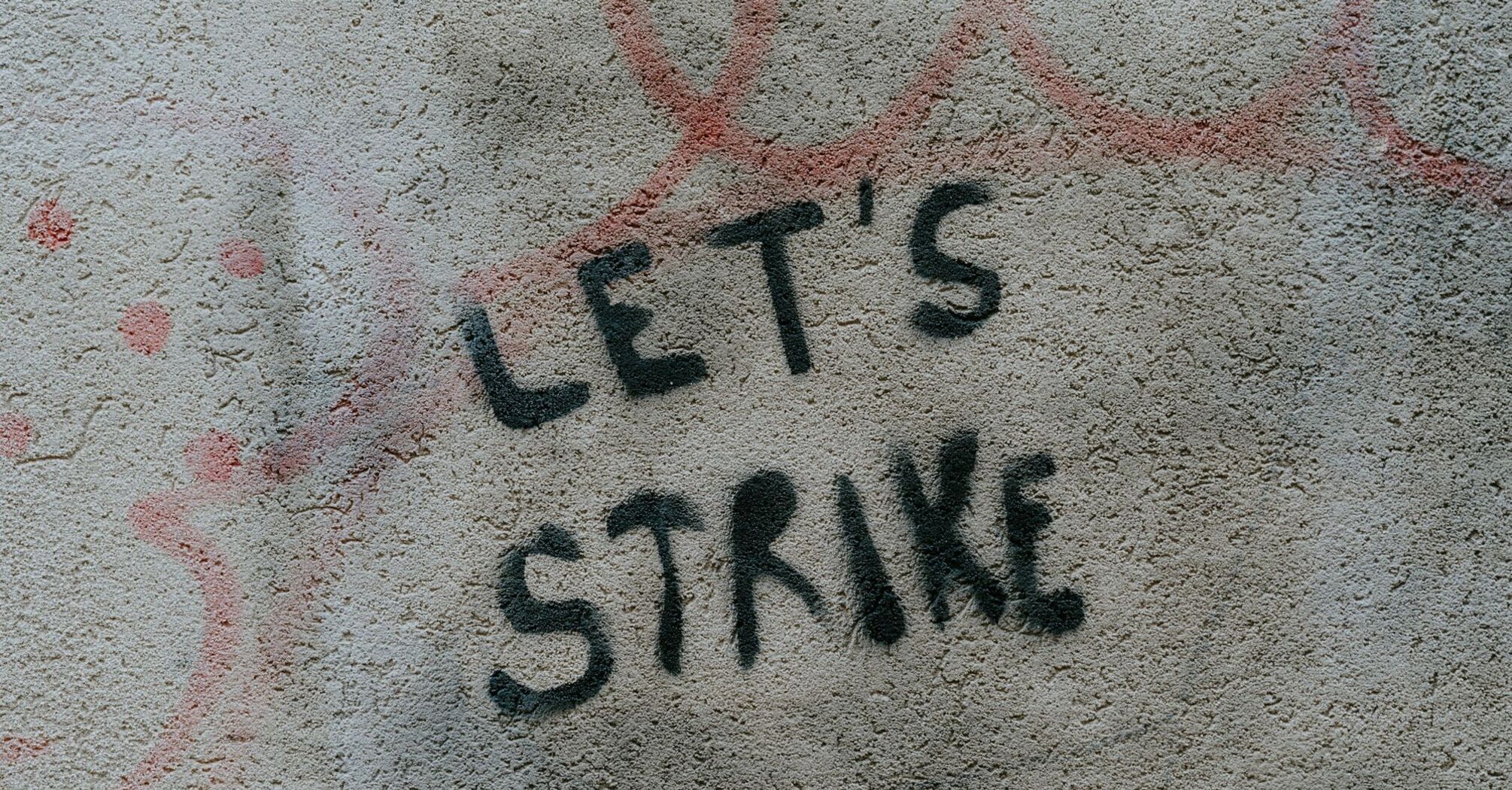 Graffiti saying 'Let's Strike' on a wall