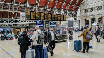 Travelers with luggage at a busy UK airport terminal