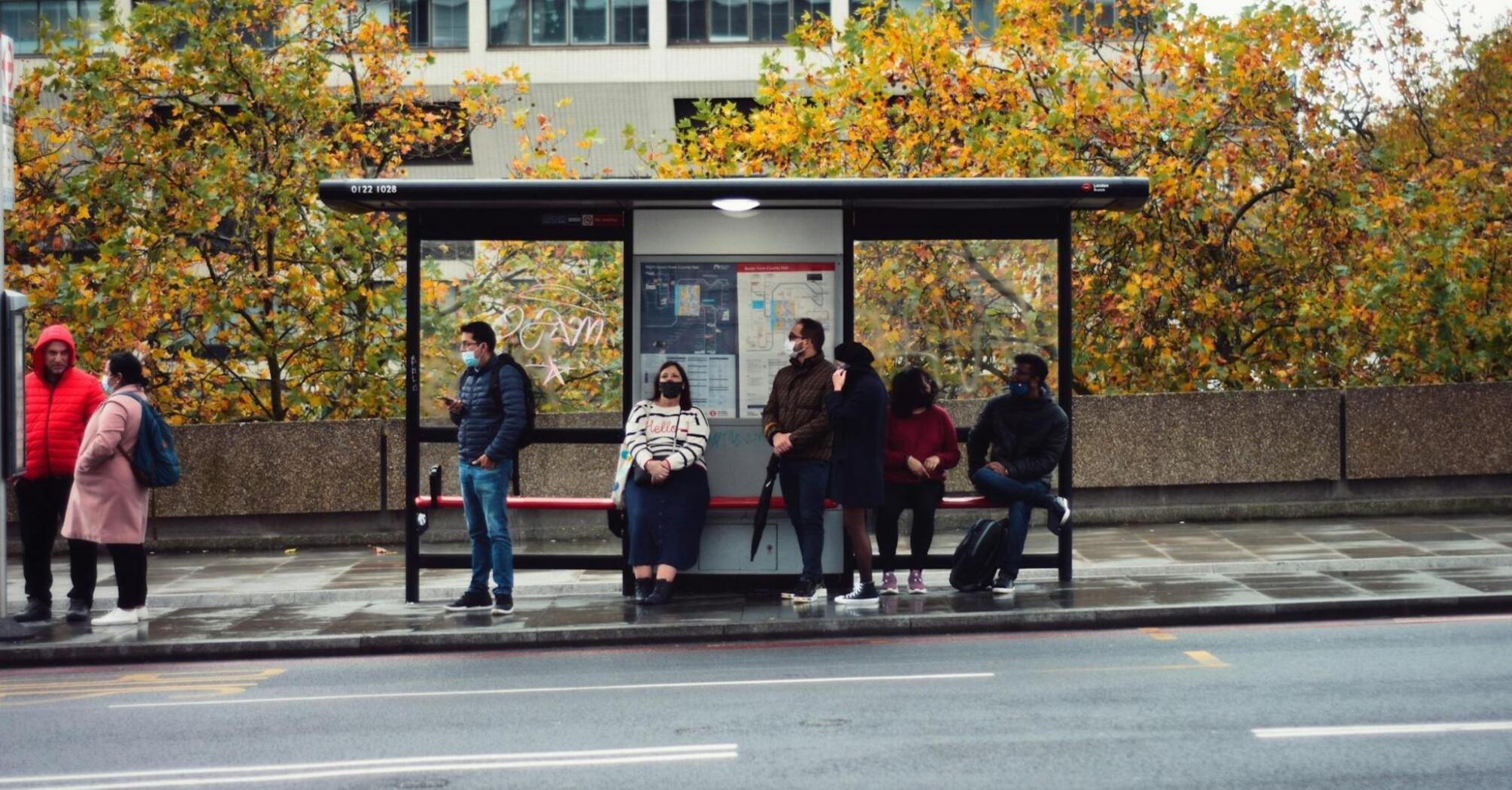 People waiting at a bus stop in an urban area