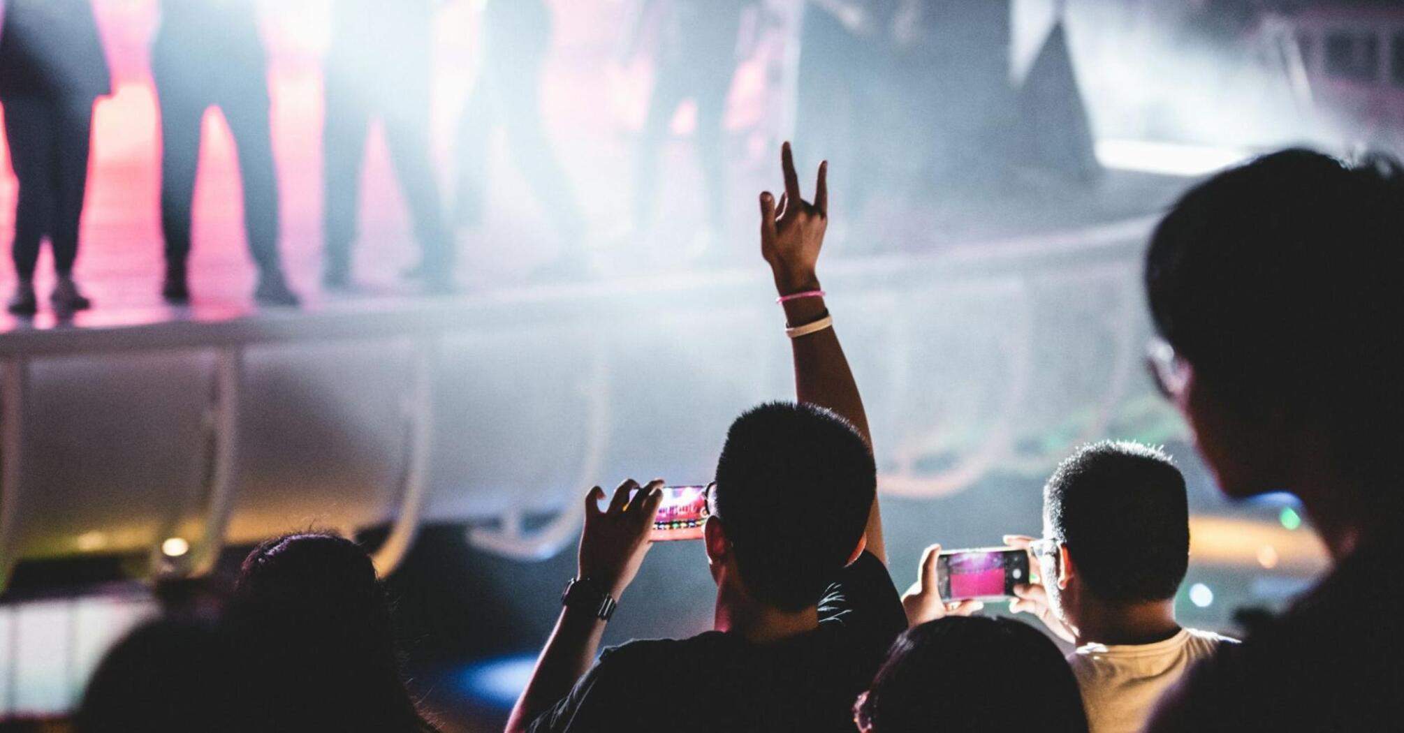 Concertgoers capturing the performance with their phones at a live music event
