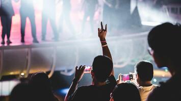 Concertgoers capturing the performance with their phones at a live music event