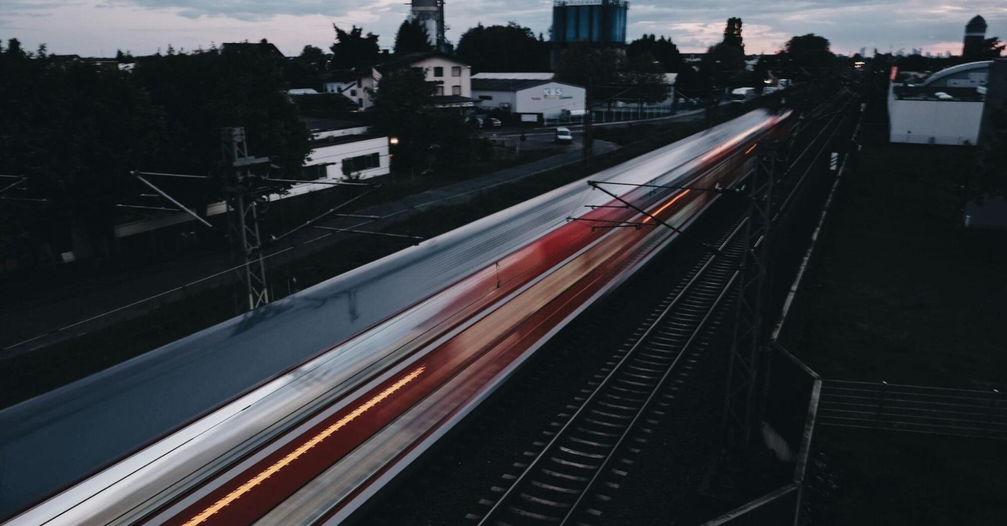  A train speeding through a suburban area during twilight