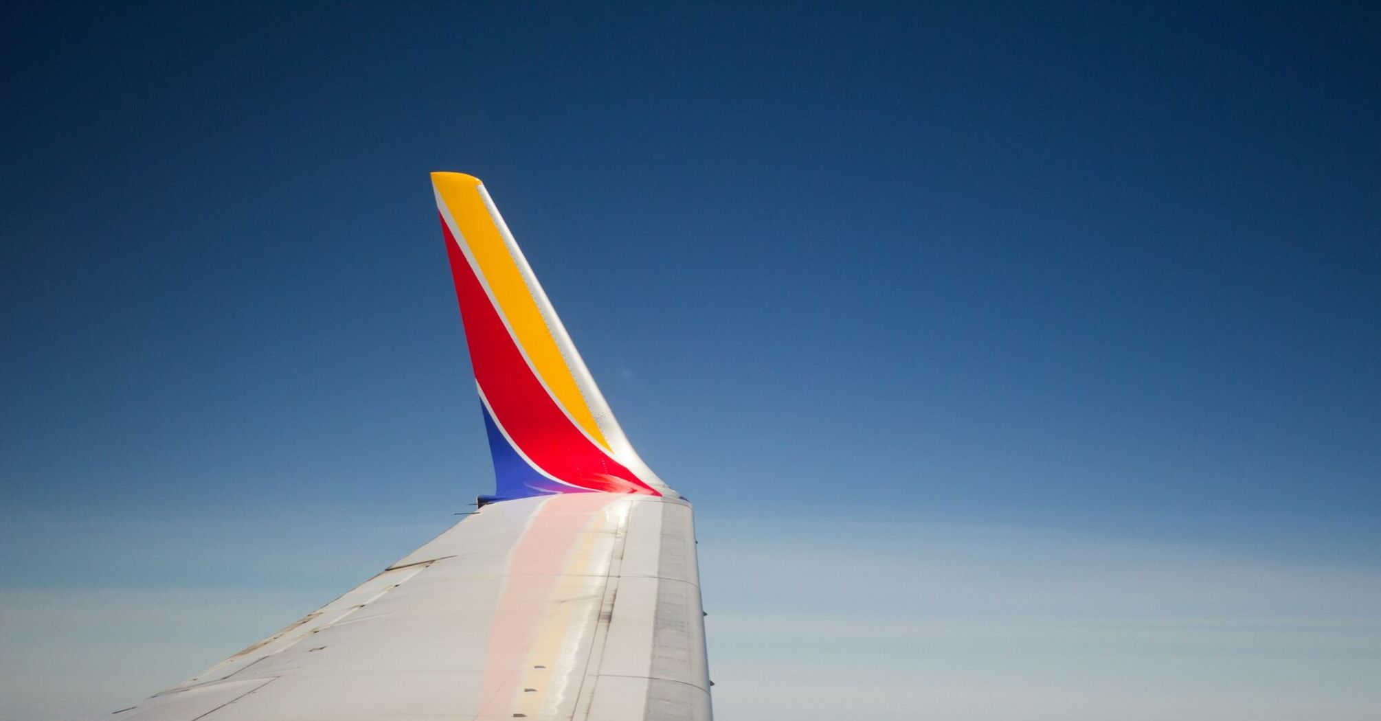 Southwest Airlines wing in flight against a blue sky