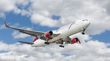 white and red flying airplane under white clouds