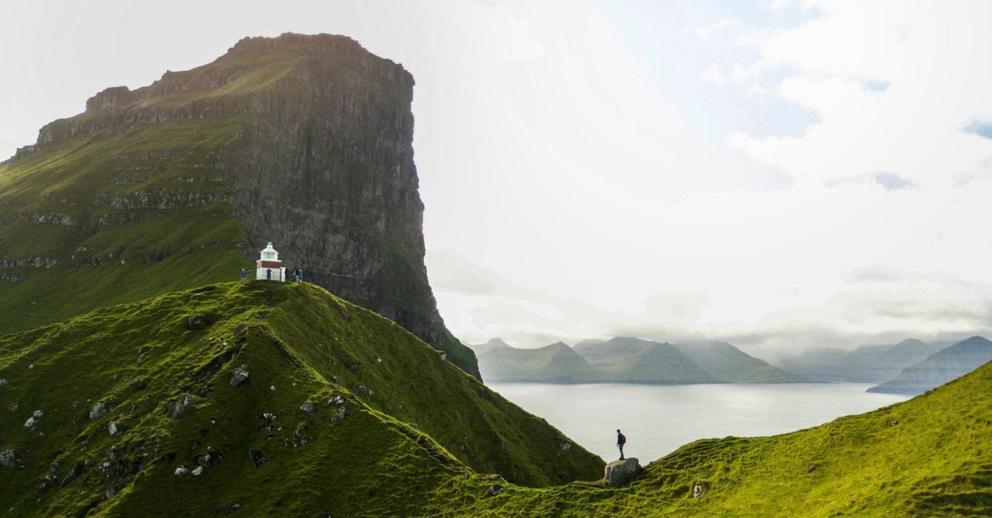 Man standing on a green mountain on Kalsoy Island