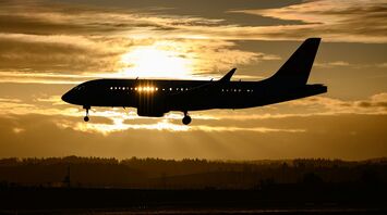 Airplane flying at sunset