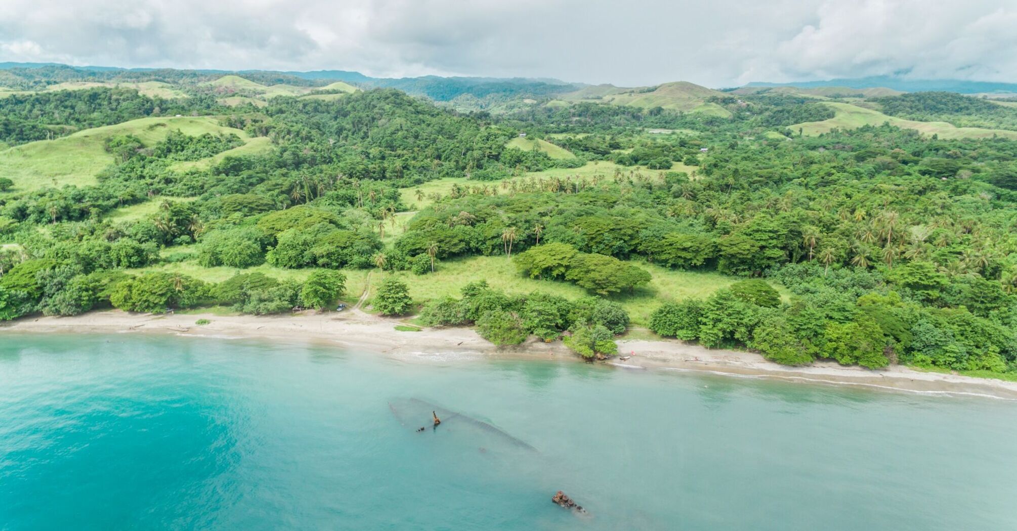 Aerial view of lush green landscape and beach on the Solomon Islands