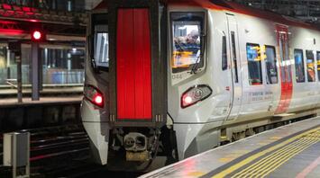 A TfW train at a station platform at night