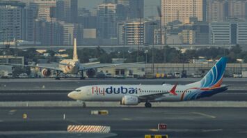 Flydubai airplane on runway with city skyline in background