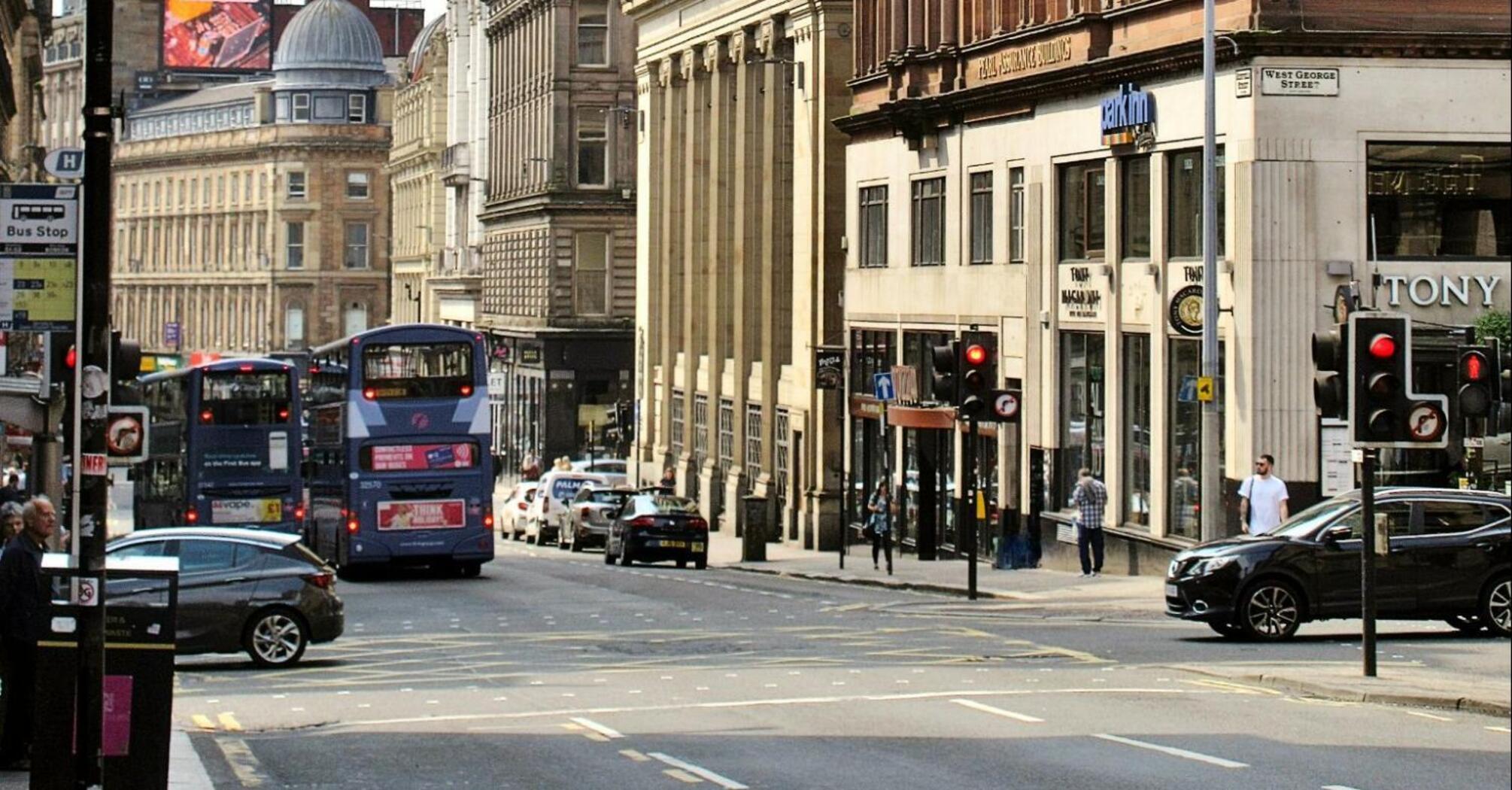 City street in Glasgow with buses and historic buildings